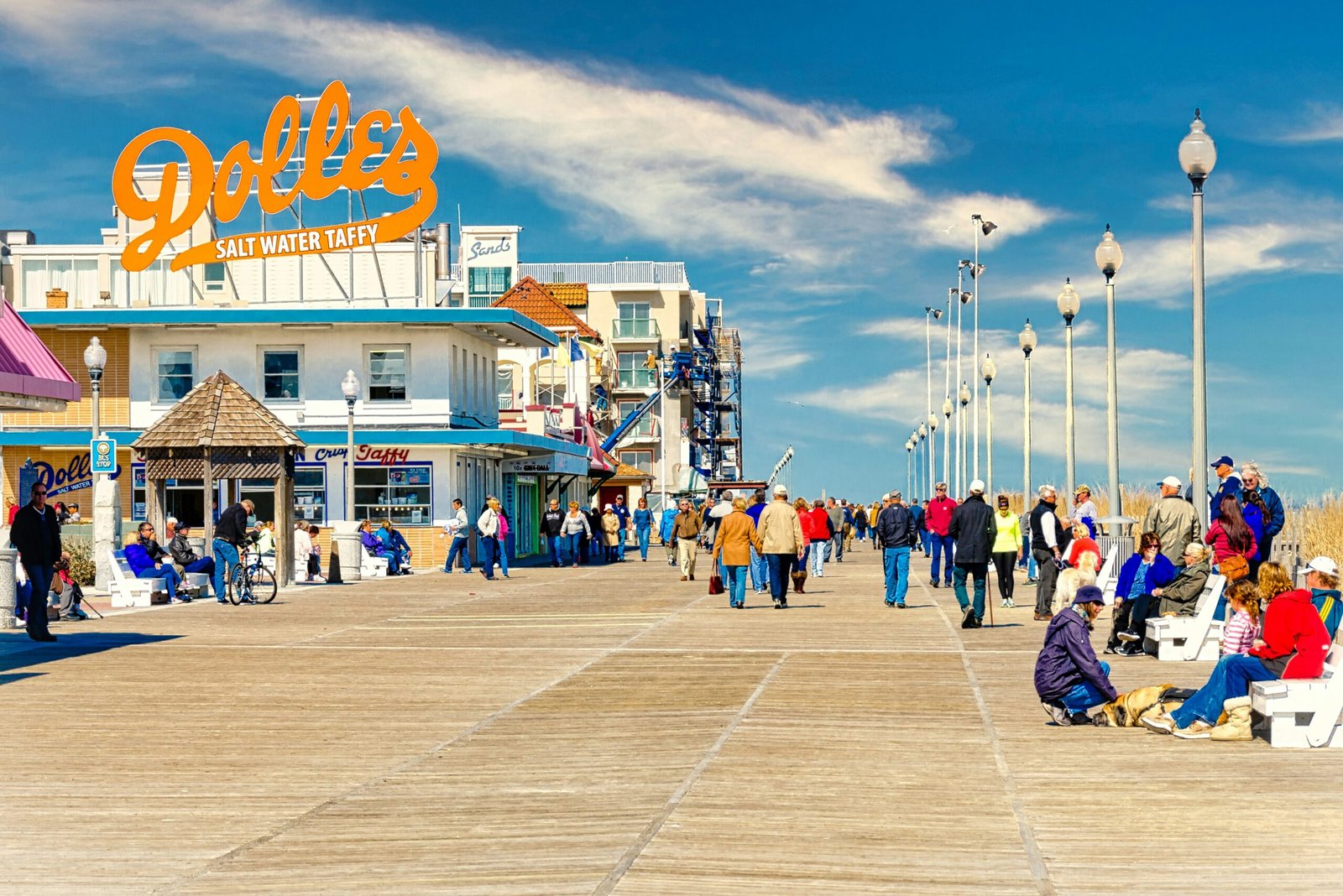 a group of people walking on a boardwalk next to a building