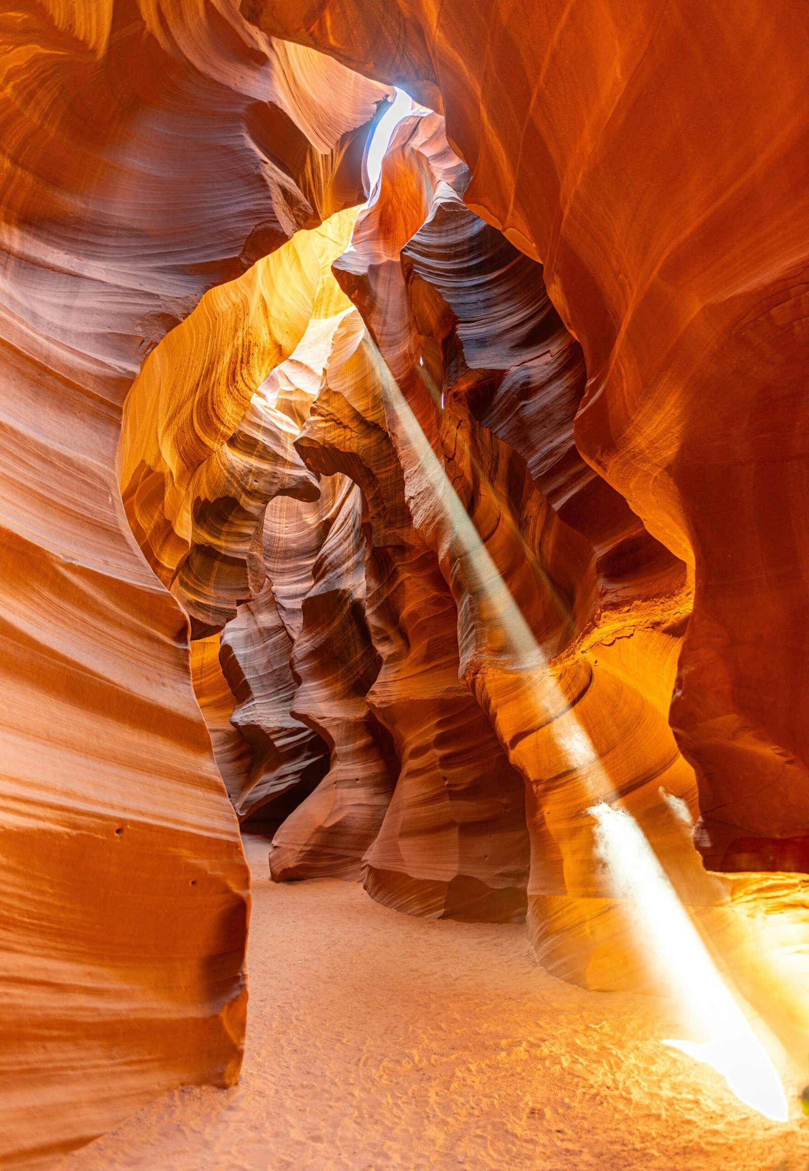 a light shines through a narrow slot in a canyon