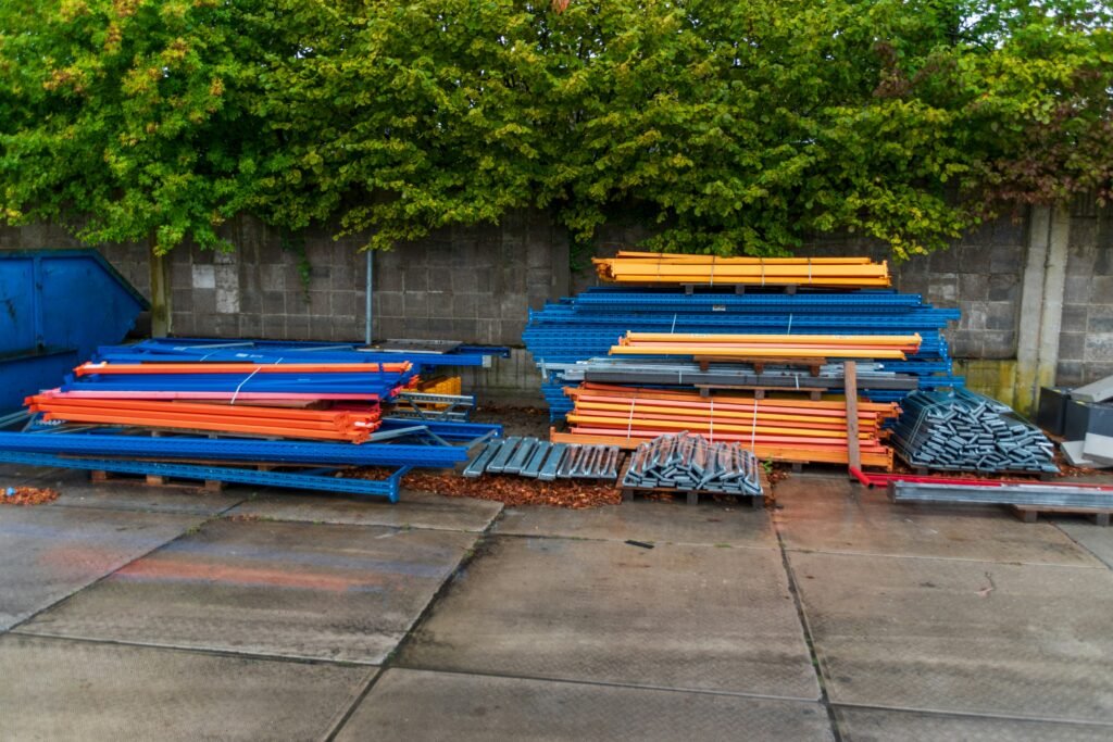 Construction materials stacked outdoors near a wall.