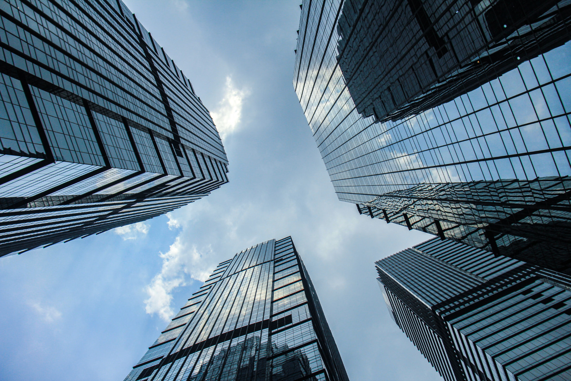 Reflective commercial office towers viewed from below for Commercial Real Estate Capital Solutions