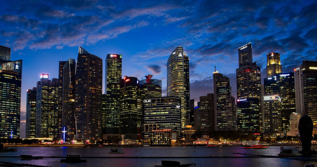 Illuminated business district skyline at dusk for Owner-Occupied Commercial Real Estate Loans | Thorne CRE