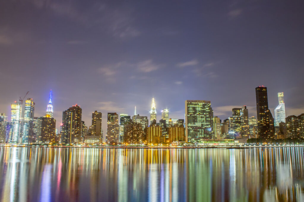 City towers and waterfront reflections at night for CRE Ownership Changes & SBA Loan Financing Guide