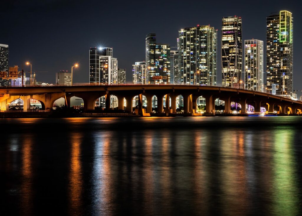 Urban bridge and high-rise skyline illuminated at night for Abrar Jafar | Commercial Real Estate Finance Author