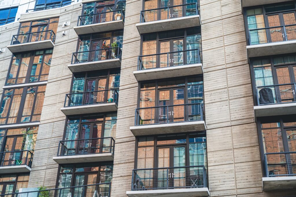 Modern multifamily building with glass-fronted balconies for Real Estate Investment Guides & Financing | Thorne CRE