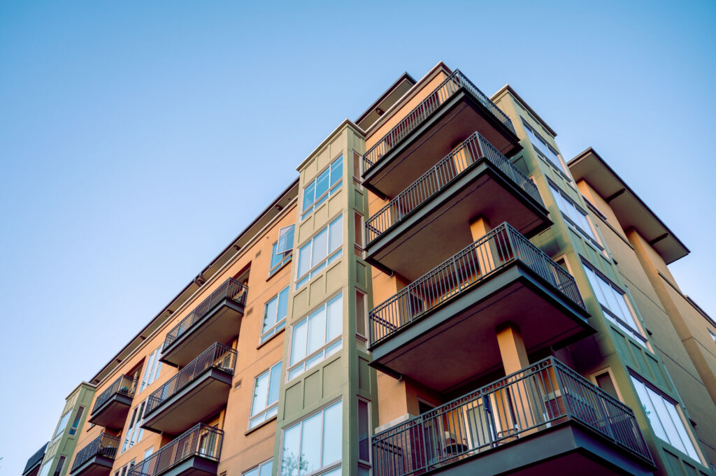 Contemporary apartment building with stacked balconies for Specialized Debt Advisory for Commercial Construction Loans ($20M+