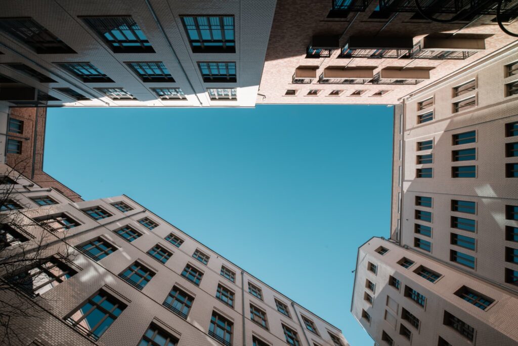 Urban apartment buildings surrounding a courtyard under a blue sky for Commercial Loan Penalty Schedules & Prepayment | Thorn