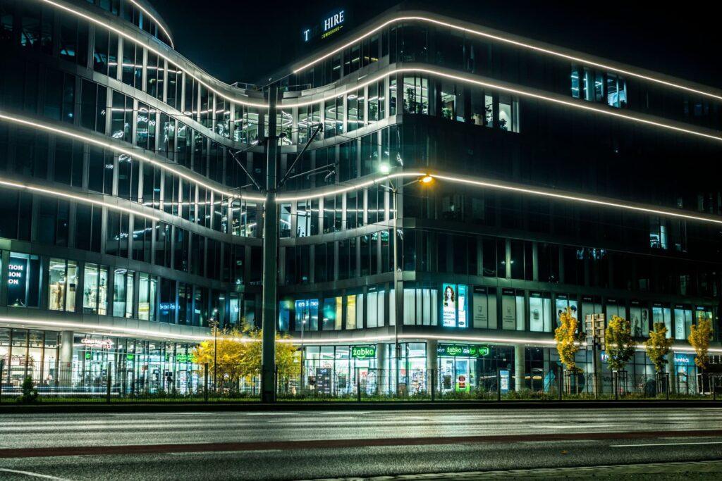 Glass-facade office building with street-level shops at night for Cash-on-Cash Return Formula in CRE | Thorne CRE