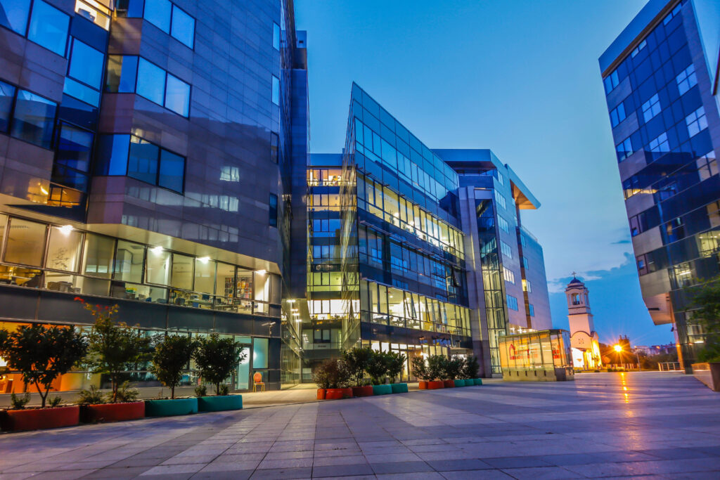 Glass office buildings surrounding a stone-paved courtyard at dusk for Commercial Loan Prepayment Penalty Guide | Thorne CRE