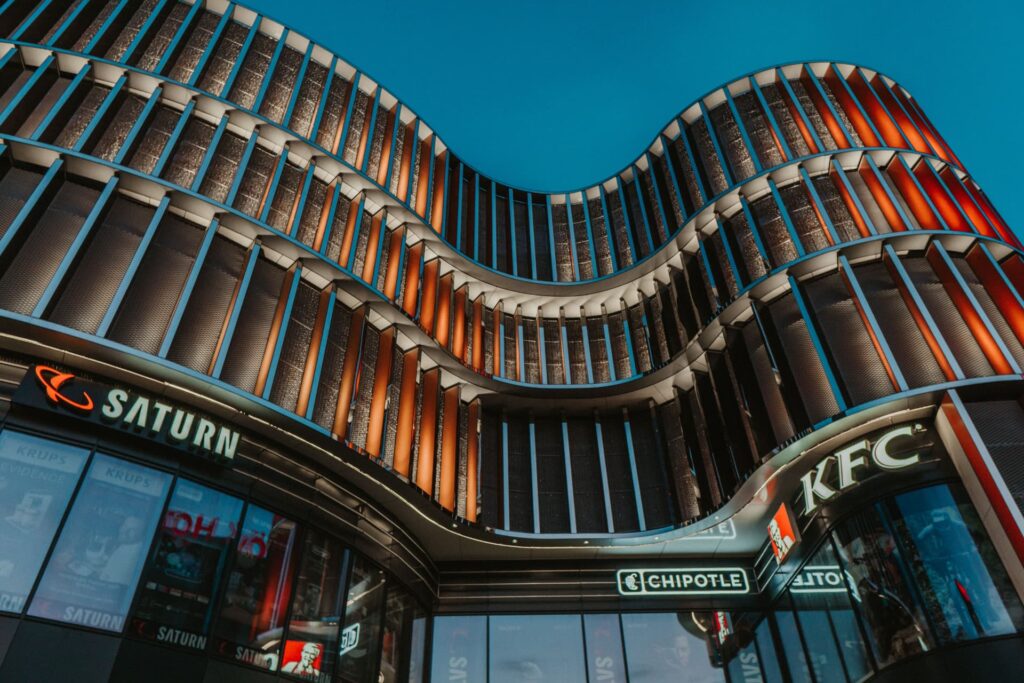 Commercial building with a wavy facade and illuminated vertical fins at twilight for Commercial Real Estate Debt Advisory Ser