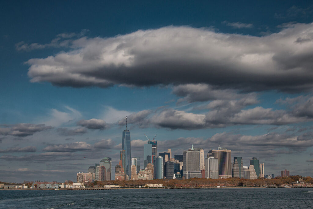 Lower Manhattan skyline beneath dramatic clouds across the harbor for SBA Referral Fee Programs for Professional Advisors: Co