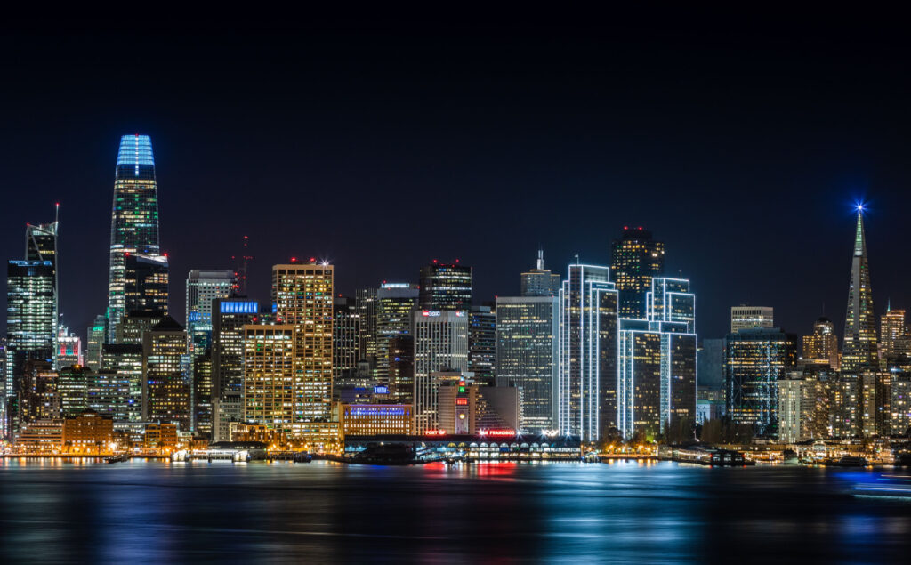 San Francisco skyline at night with lit towers reflected in the bay for SBA Loans for Mixed-Use and Multi-Tenant Properties