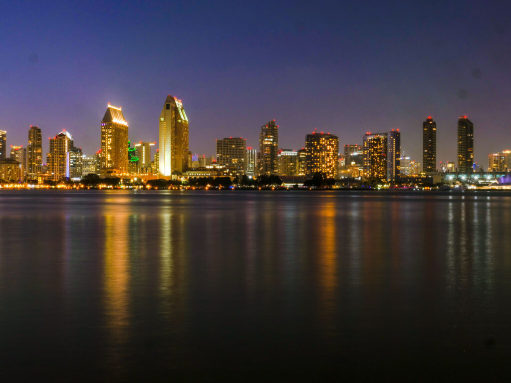 City skyline at night with golden building reflections on calm water for SBA Lender Selection for Referral Partners: Evaluati